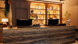 Un espace d’accueil avec un comptoir en bois, des étagères ornées d’objets décoratifs et une enseigne indiquant « KLEINE SPIER ».