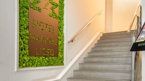 A staircase with a green wall panel displaying 'HOTEL MADANIS LICEO'. - Hotel Madanis Liceo (L'Hospitalet de Llobregat)