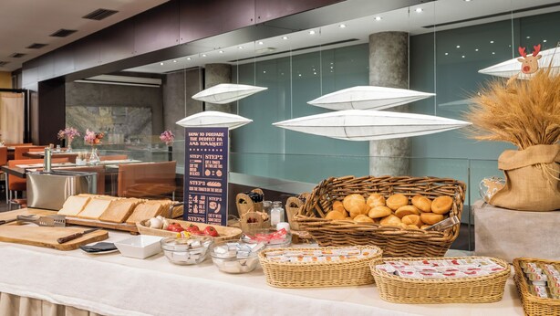 A buffet setup with bread, tomatoes, and various condiments. - Hotel Madanis Liceo (L'Hospitalet de Llobregat)