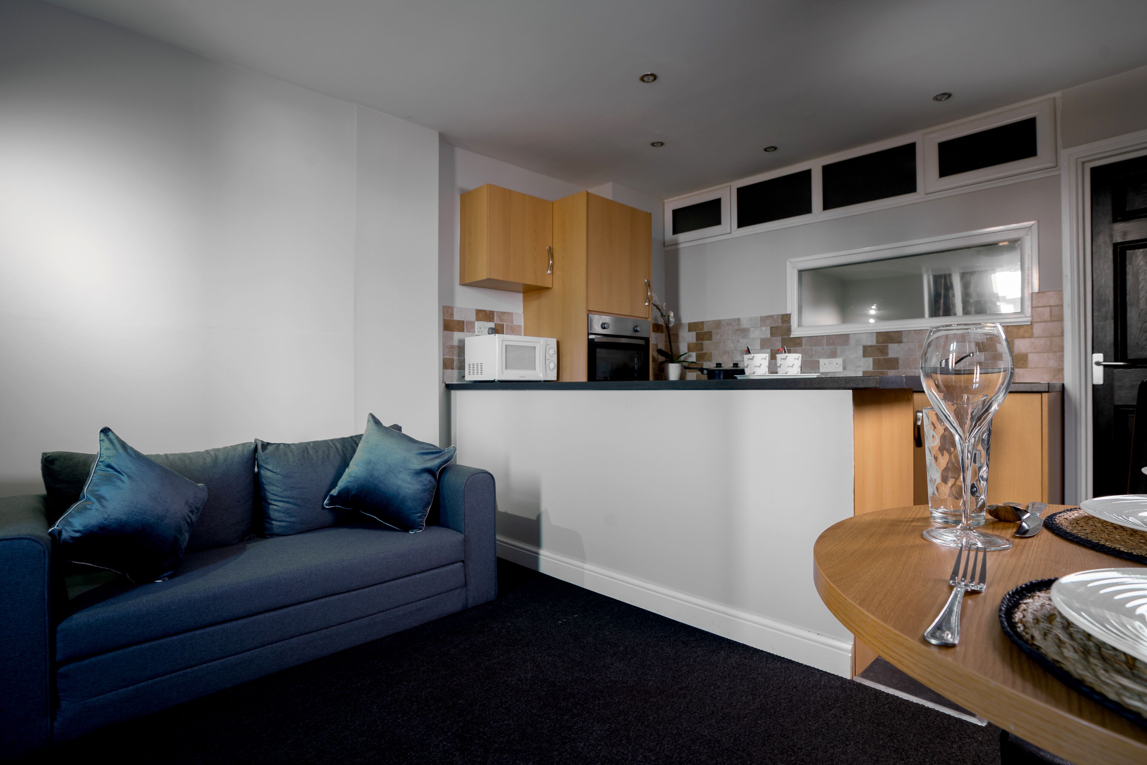 A modern kitchen with wooden cabinets, a microwave, and a built-in oven.