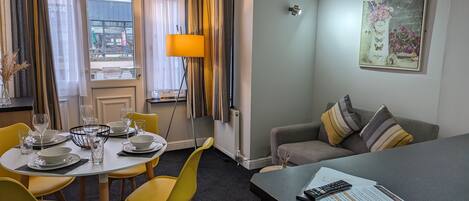 Ett hotellrum med en matplats, en soffa och ett skrivbord.