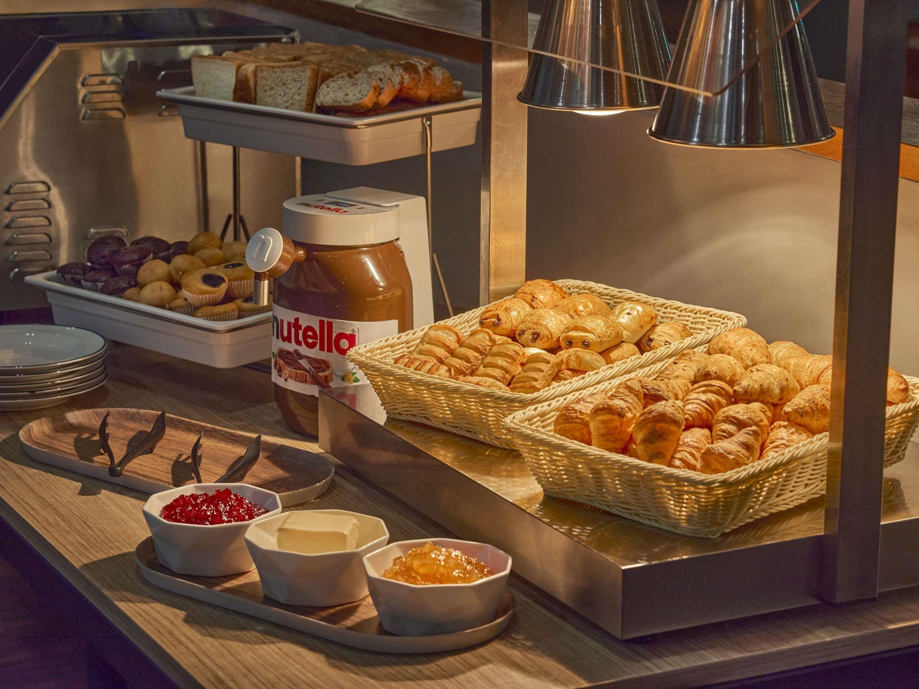 A buffet with pastries, Nutella, and various spreads.