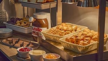 A buffet with pastries, Nutella, and various spreads.