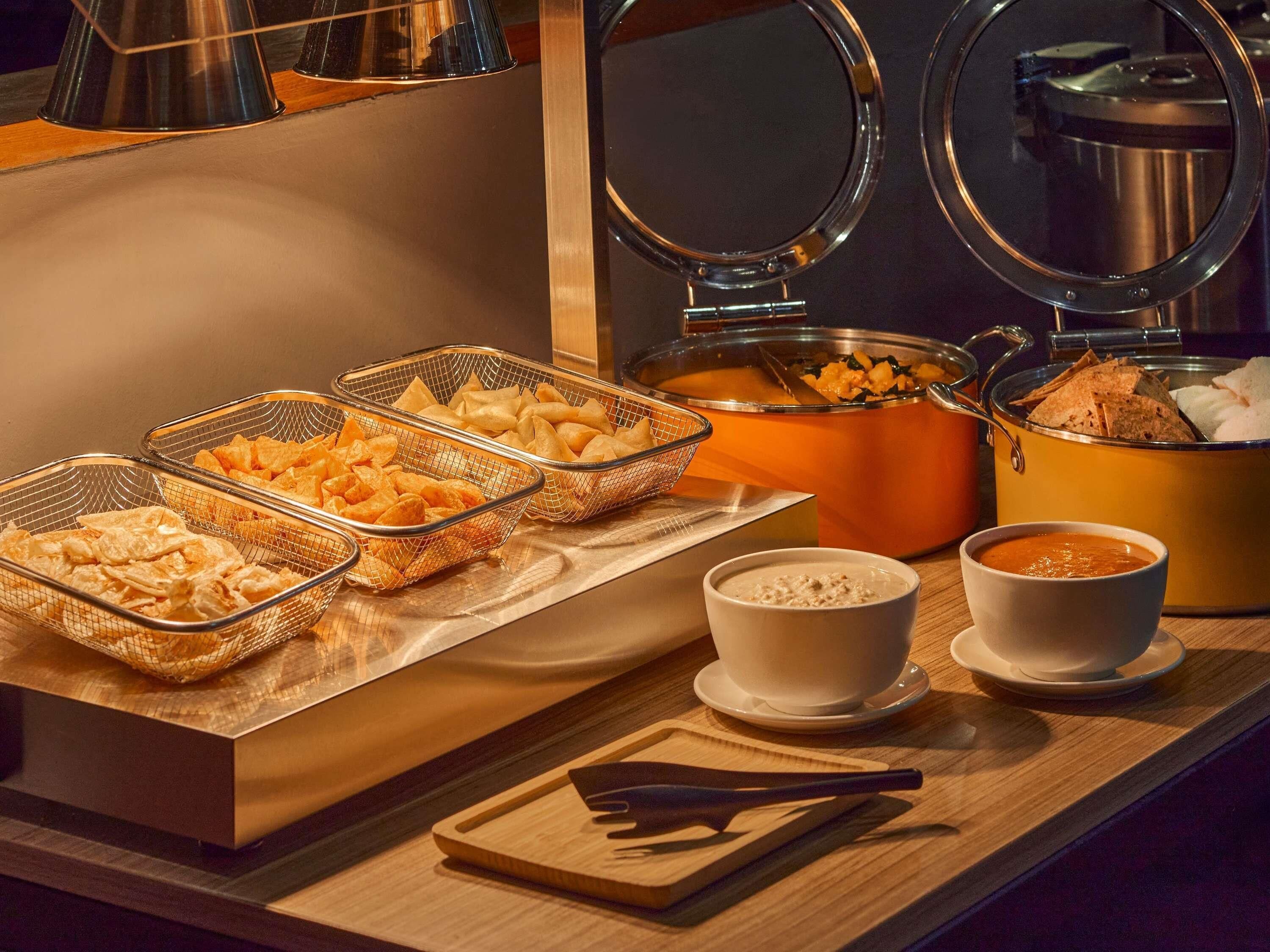 A buffet setup with various food items and containers.