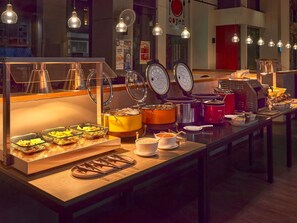 A buffet setup with various food items and serving utensils. - ibis Singapore Novena (Singapore)