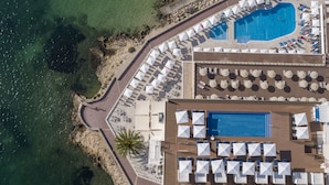 An aerial view of a resort with a large pool, sun loungers, and a beach area. - Globales Santa Lucia Hotel Adults Only +18 (Calvia)