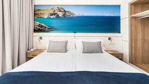 A hotel room with a bed, two bedside tables, a phone, and a painting of a coastal landscape. - Globales Santa Lucia Hotel Adults Only +18 (Calvia)