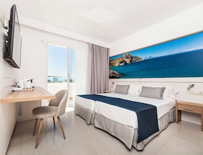A modern hotel room with a bed, a desk, a chair, a television, and a large window with a view of the sea. - Globales Santa Lucia Hotel Adults Only +18 (Calvia)