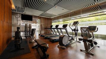 A modern gym with treadmills, weight machines, and a rowing machine.