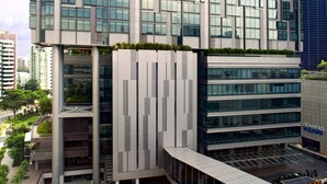 Un moderno edificio hotelero con fachada de vidrio, varios pisos y una señalización destacada que dice 'oasia hotel'.