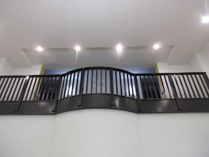 A curved black metal railing with a handrail, white walls, and recessed ceiling lights. - Best Western Plus Frisco East - McKinney (Frisco)