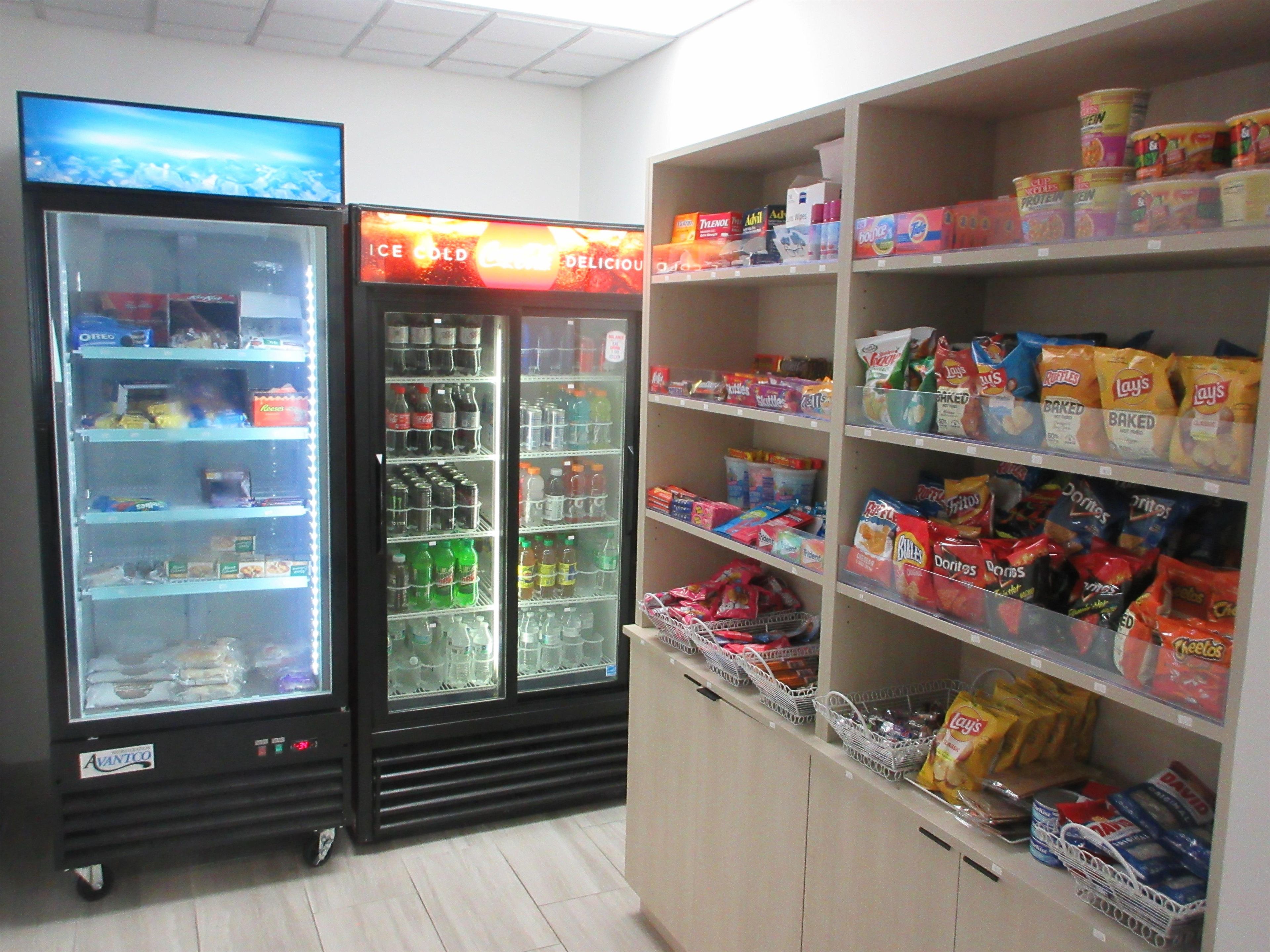 Vitrine refrigerada com diversas bebidas e lanches, e freezer com sorvetes.
