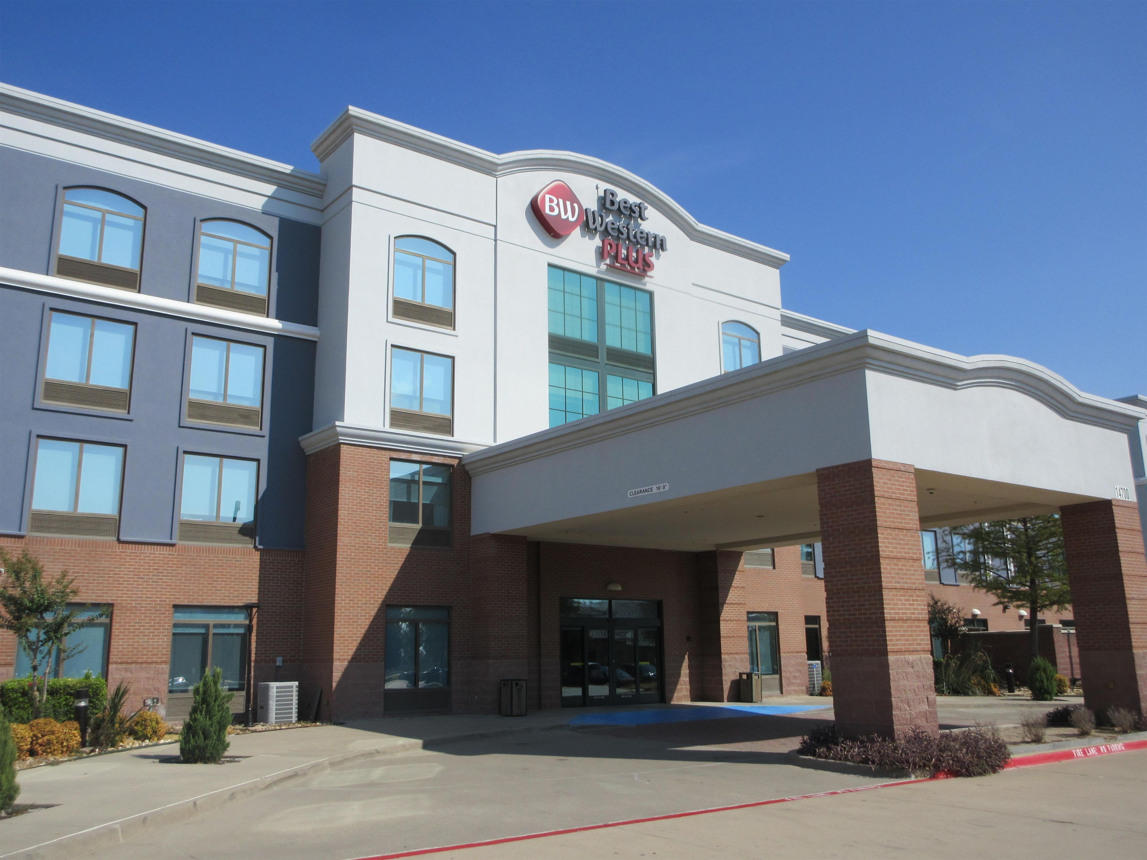 A hotel with a clear entrance, a sign indicating 'Best Western Plus', and a covered parking area.