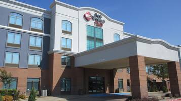 A hotel with a clear entrance, a sign indicating 'Best Western Plus', and a covered parking area.
