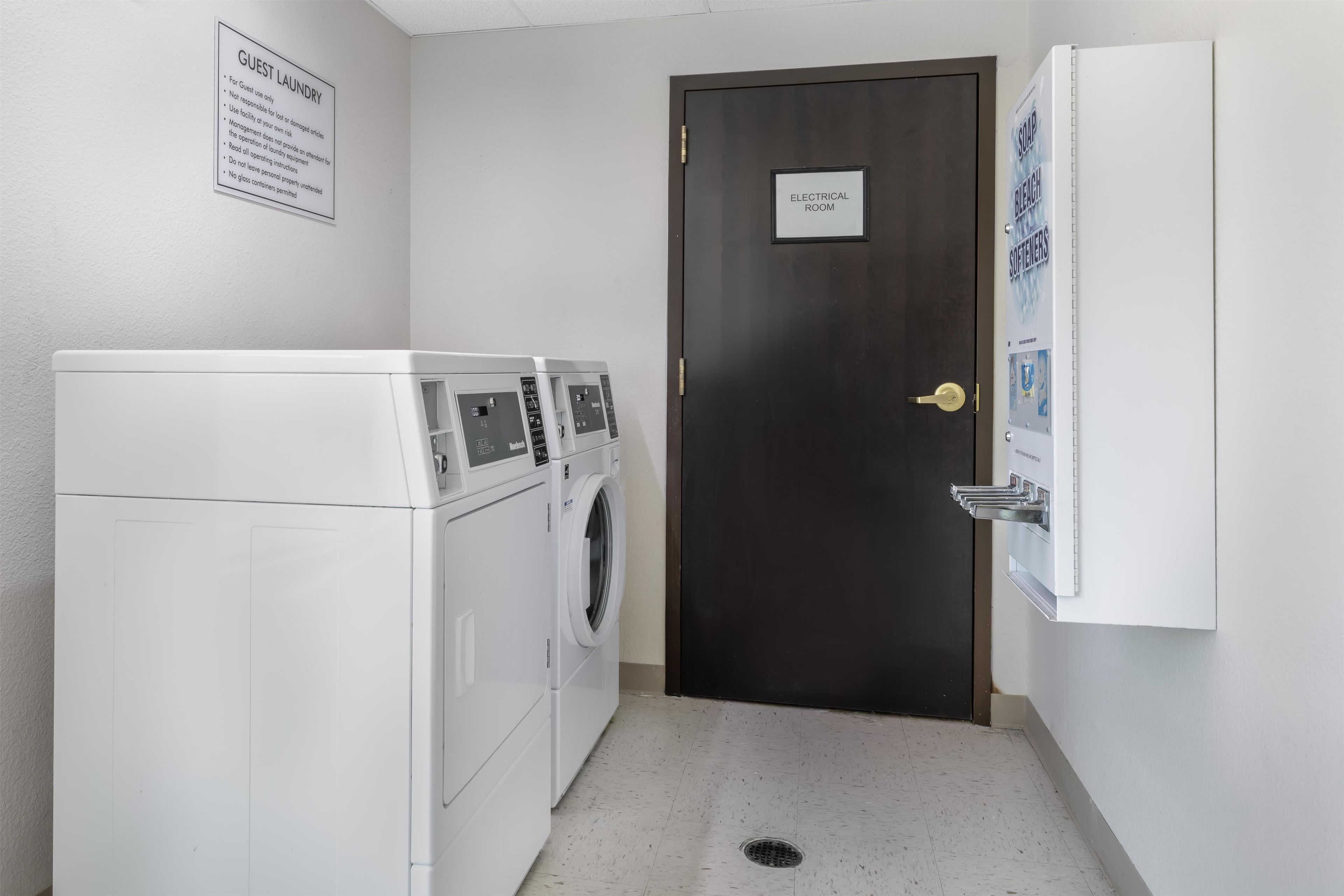 A laundry room with a door labeled 'ELECTRICAL ROOM' and a sign for 'SOAP BLEACH SOFTENERS'.
