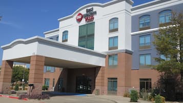 Un hotel con entrada despejada, un letrero que indica 'Best Western Plus' y un cartel que muestra 'Clearance 16-0'.
