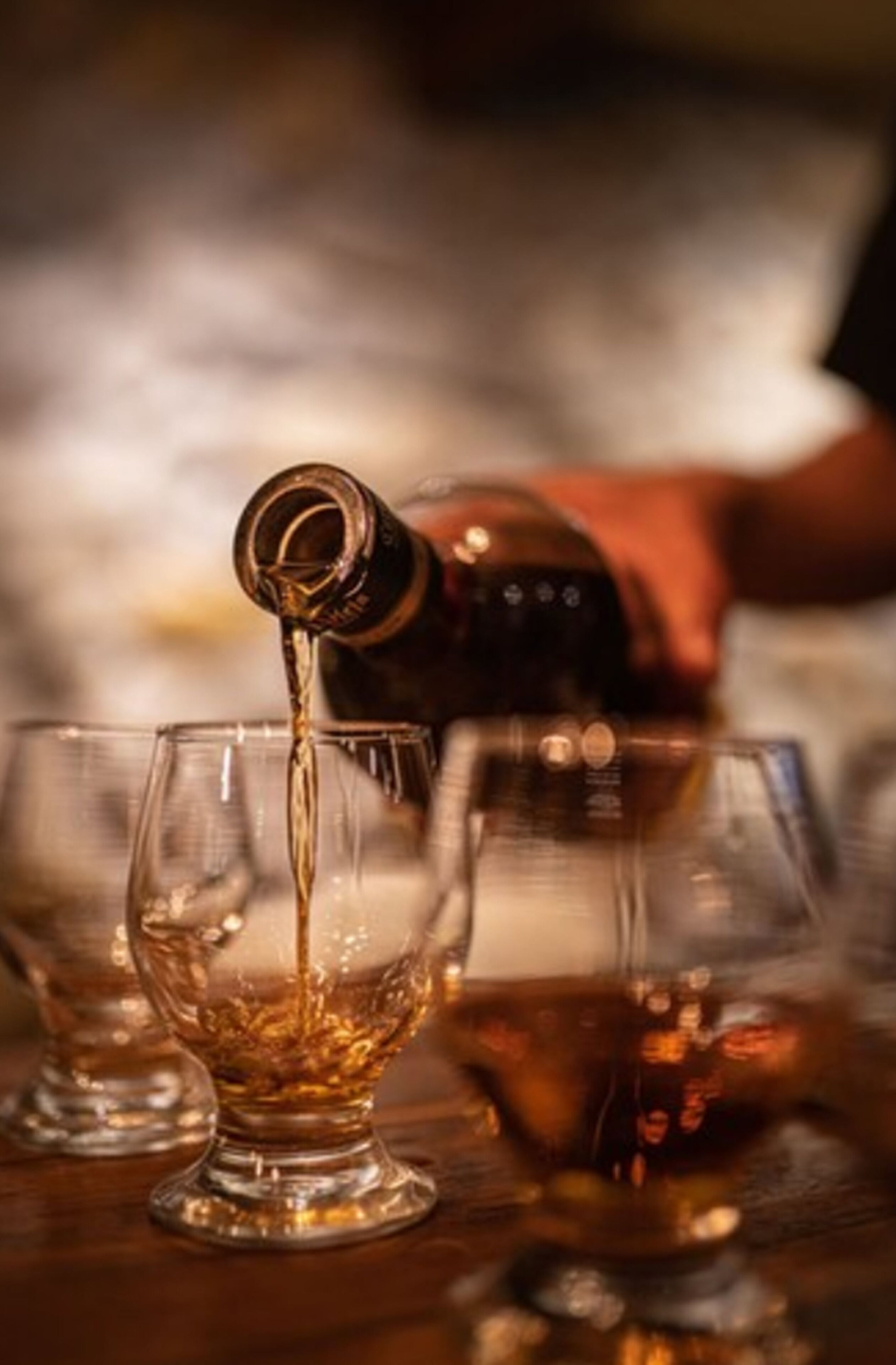 A bottle pouring liquid into a glass.