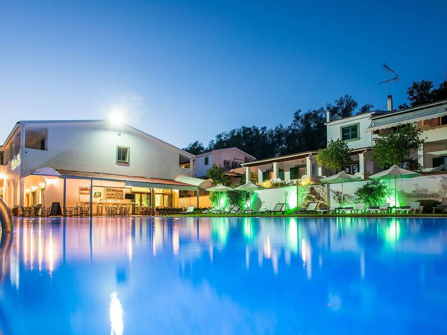 Una piscina al aire libre, sombrillas, sillones reclinables de piscina