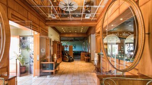 A hallway with wooden paneling, a large mirror, and a tiled floor. - Paradise Inn (Corfu)