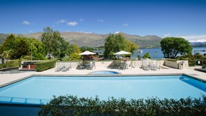 A rectangular swimming pool with a view of mountains and a lake. - Lakeside Apartments (Wanaka)