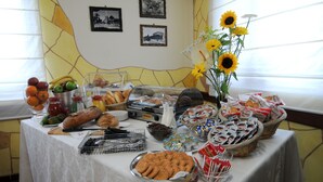 Una mesa de buffet con diversos alimentos y un jarrón de girasoles.
