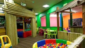 A play area with a ball pit, tables, chairs, and a small toy car. - Southport Holiday Park (Southport)