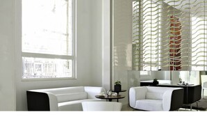 A modern living room with a white sofa, a small round table, and a decorative screen. - Meluha The Fern Mumbai, Powai, Series by Marriott (Mumbai)