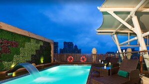 A rooftop pool with a waterfall, lounge chairs, and a cityscape view in the background. - Meluha The Fern Mumbai, Powai, Series by Marriott (Mumbai)