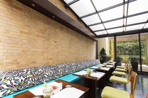 Un ristorante con un lungo bancone, una panca decorata e un'area vetrata.