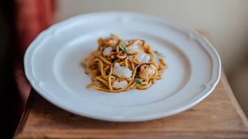 A plate of noodles with shrimp on a white plate.