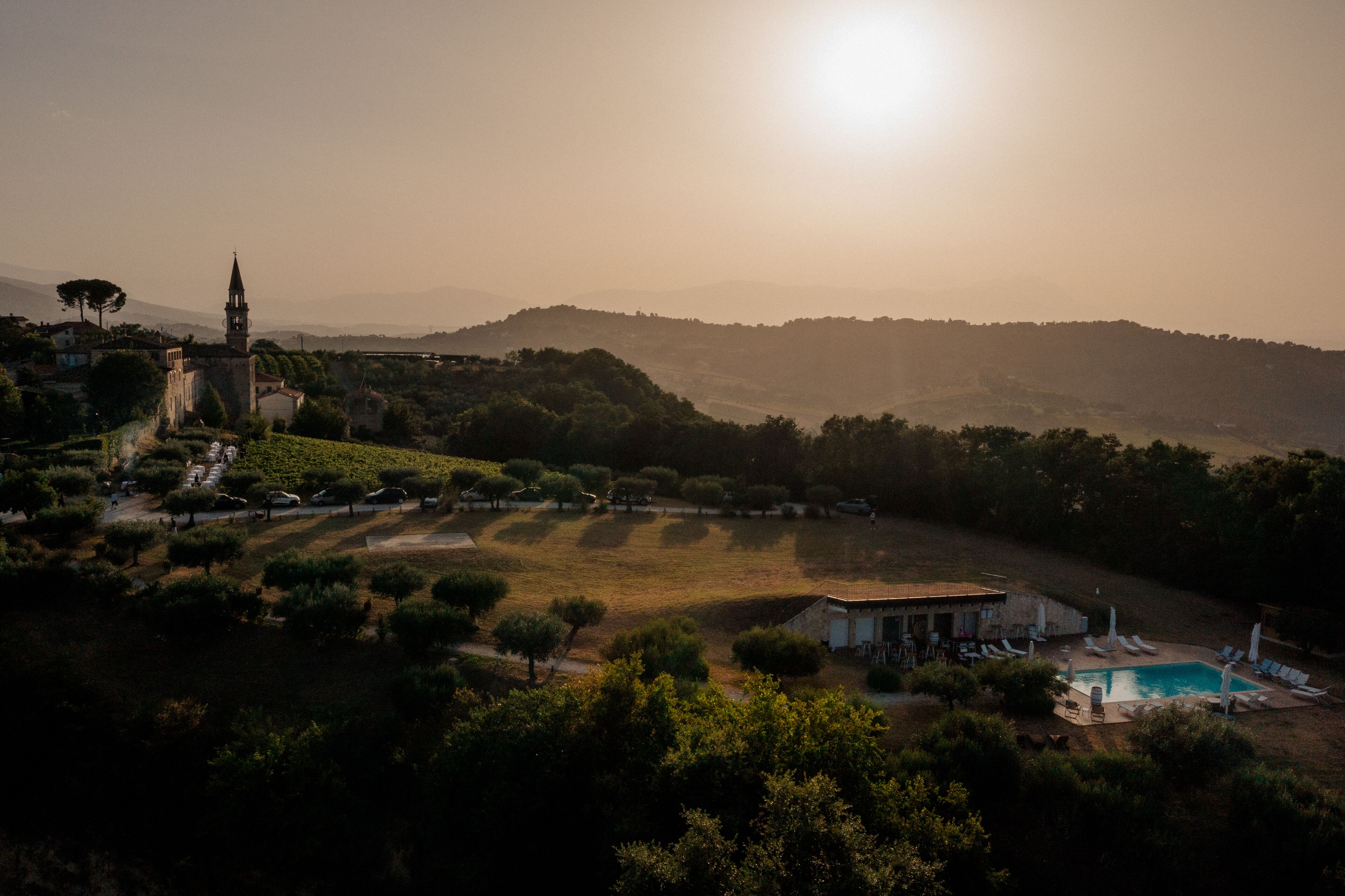 Una villa con piscina, rodeada de árboles y colinas.