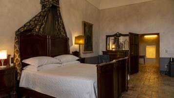 Une chambre à coucher de style traditionnel, avec un lit à baldaquin, une armoire en bois, un miroir et une petite table avec une lampe.