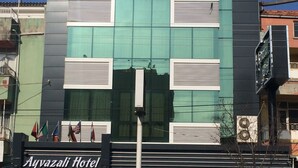 A modern hotel with a glass facade, multiple windows, and a sign indicating it is the Ayvazali Hotel. - Ayvazali Hotel (Bergama)