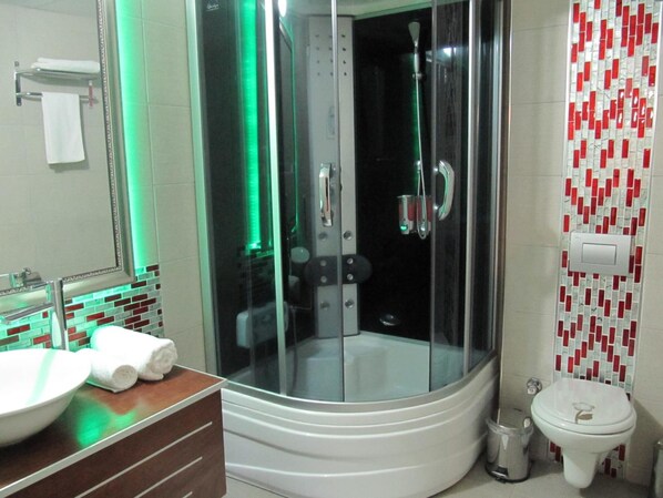 Ein Badezimmer mit Duschkabine, Waschbecken in Weiß und Toilette.