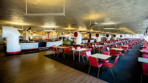 Une cafétéria spacieuse, dotée de hauts plafonds et offrant de nombreuses places assises.