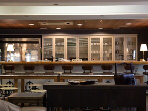 A restaurant with a bar area, wooden tables, and chairs. - Shirahamakan (Shirahama)