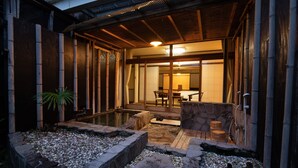 A traditional Japanese-style room with tatami mats, a wooden ceiling, and a stone water feature. - Shirahamakan (Shirahama)