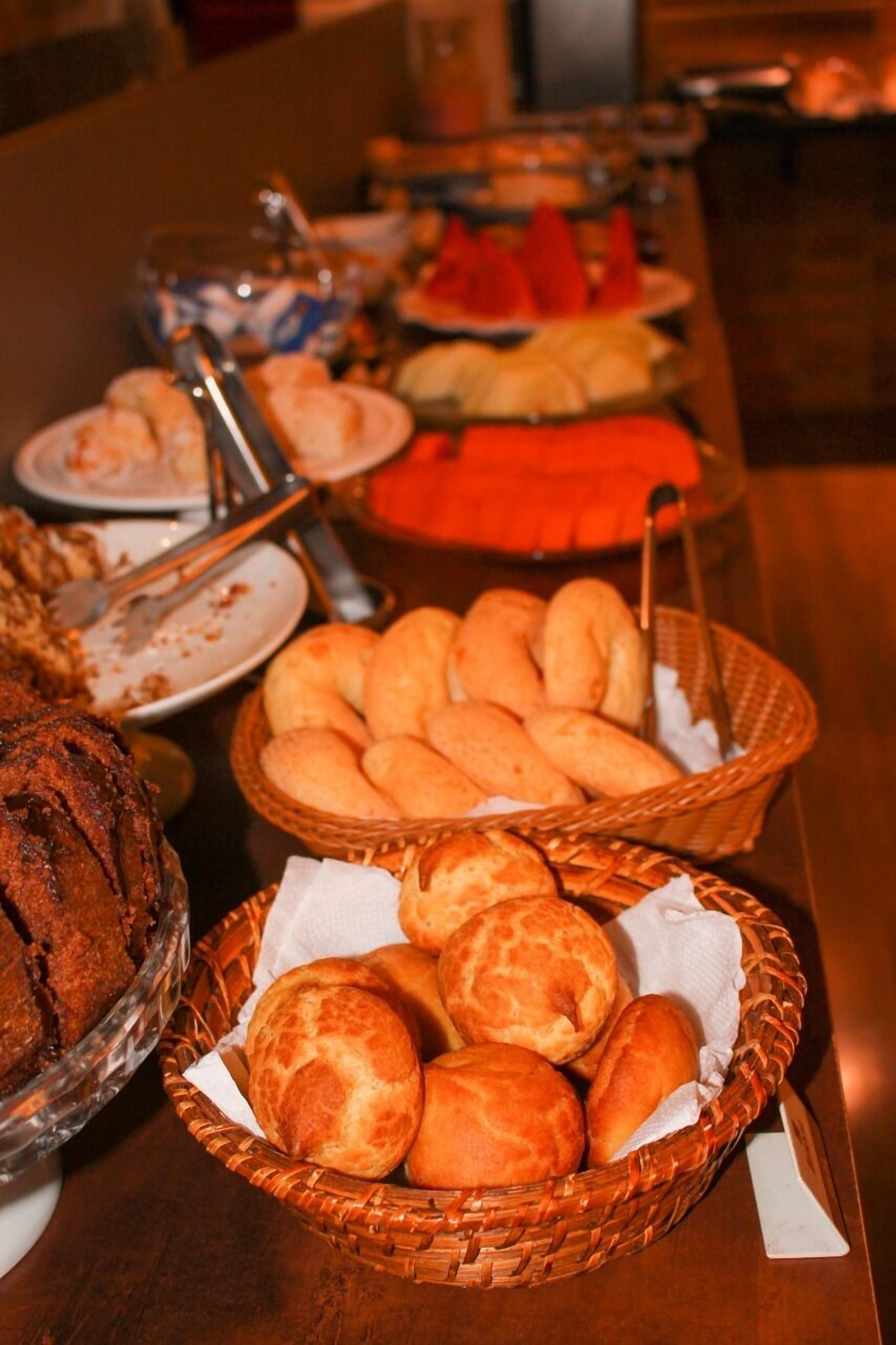Una mesa de buffet con diversos alimentos, incluyendo pan y repostería.