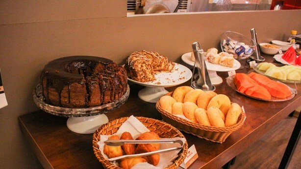 A buffet with various food items including cakes, pastries, and bread. - Bernal Hotel (Ituiutaba)