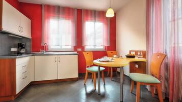Una cocina moderna con comedor, que incluye un lavamanos, armarios y una mesa con sillas.