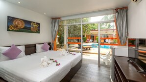 A hotel room with a large bed, two pillows, a painting, a TV, and a view of an outdoor swimming pool. - Phuket Sea Resort (Rawai)