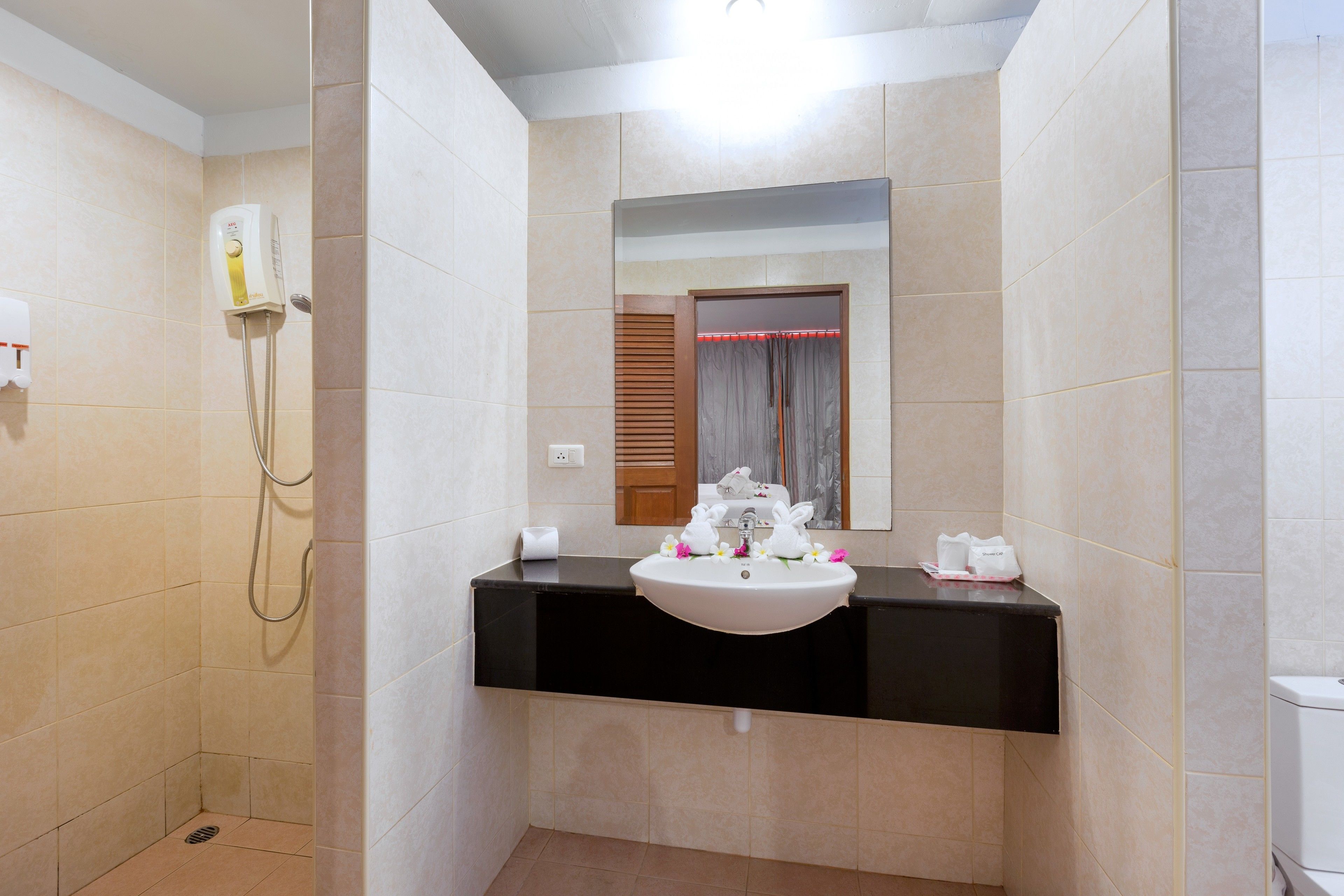 A bathroom with a shower, a sink, and a mirror.