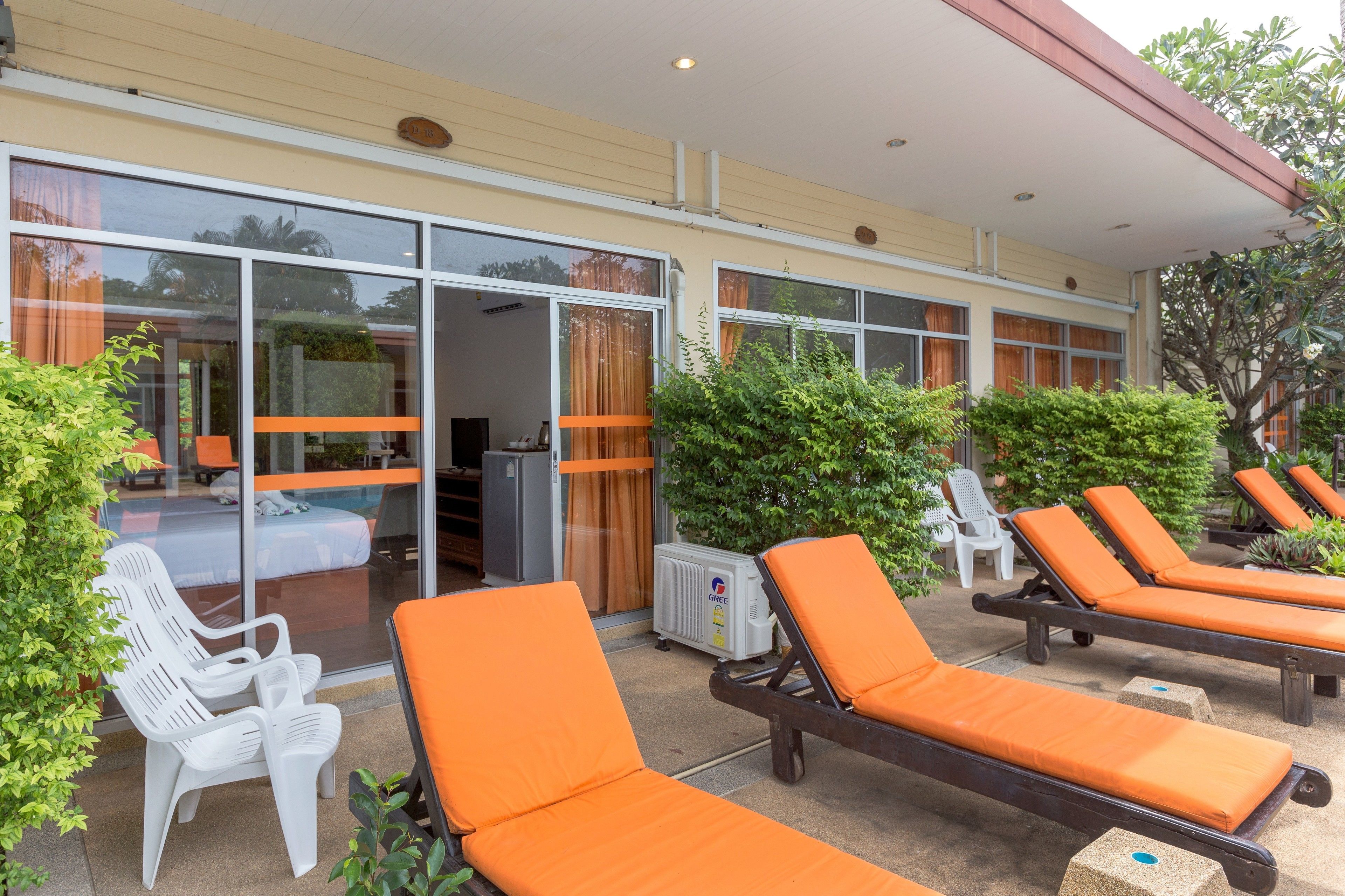 A hotel with outdoor lounge chairs and a pool area.