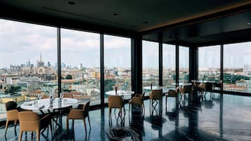 A modern dining area with large windows offering a city view.