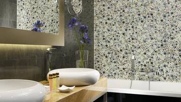 Un baño con un lavamanos grande de color blanco, un espejo y una pared de mosaicos.