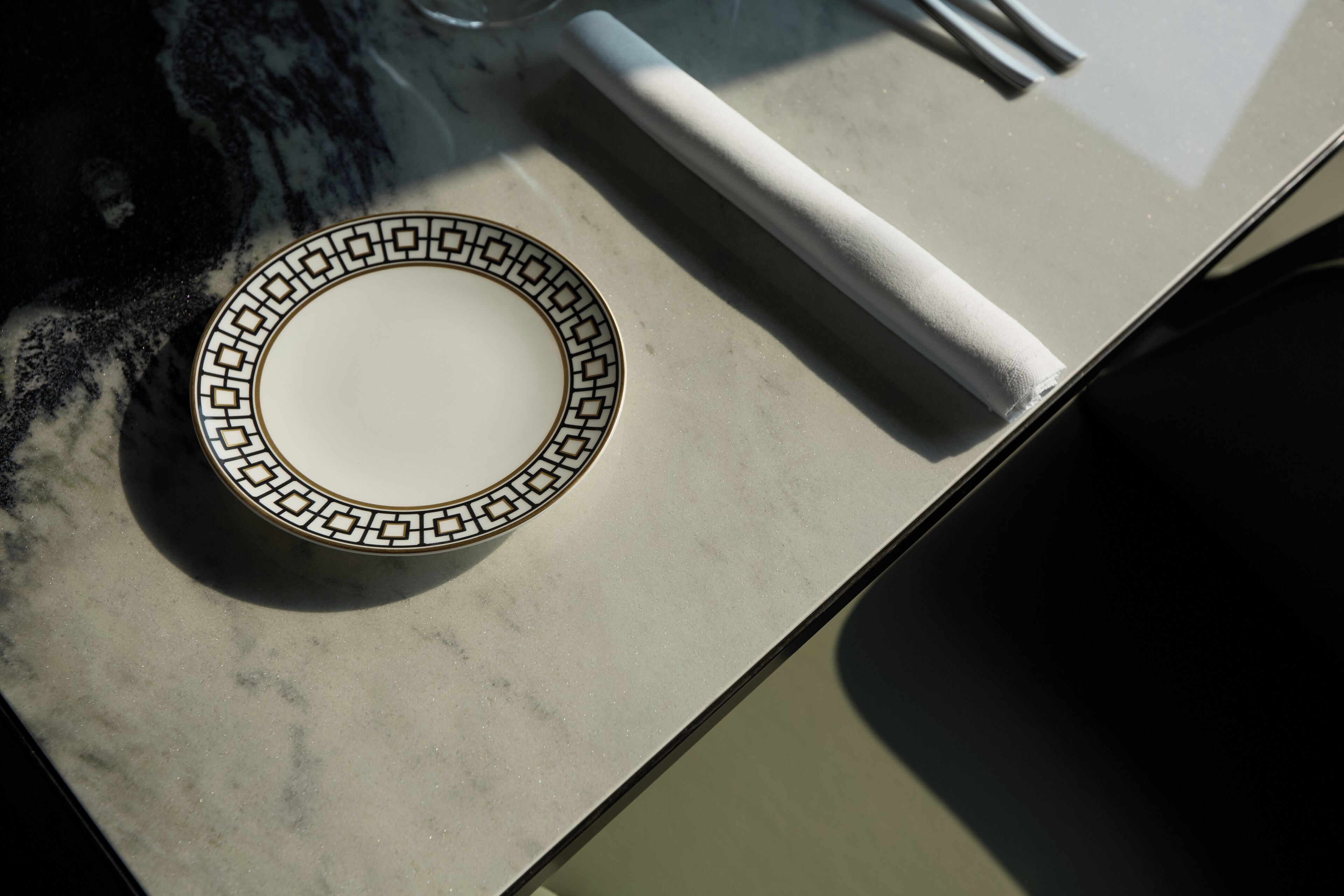 A plate with a geometric pattern on a marble countertop.