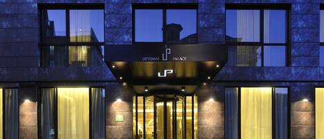 The entrance to Uptown Palace with a revolving door and illuminated signage.