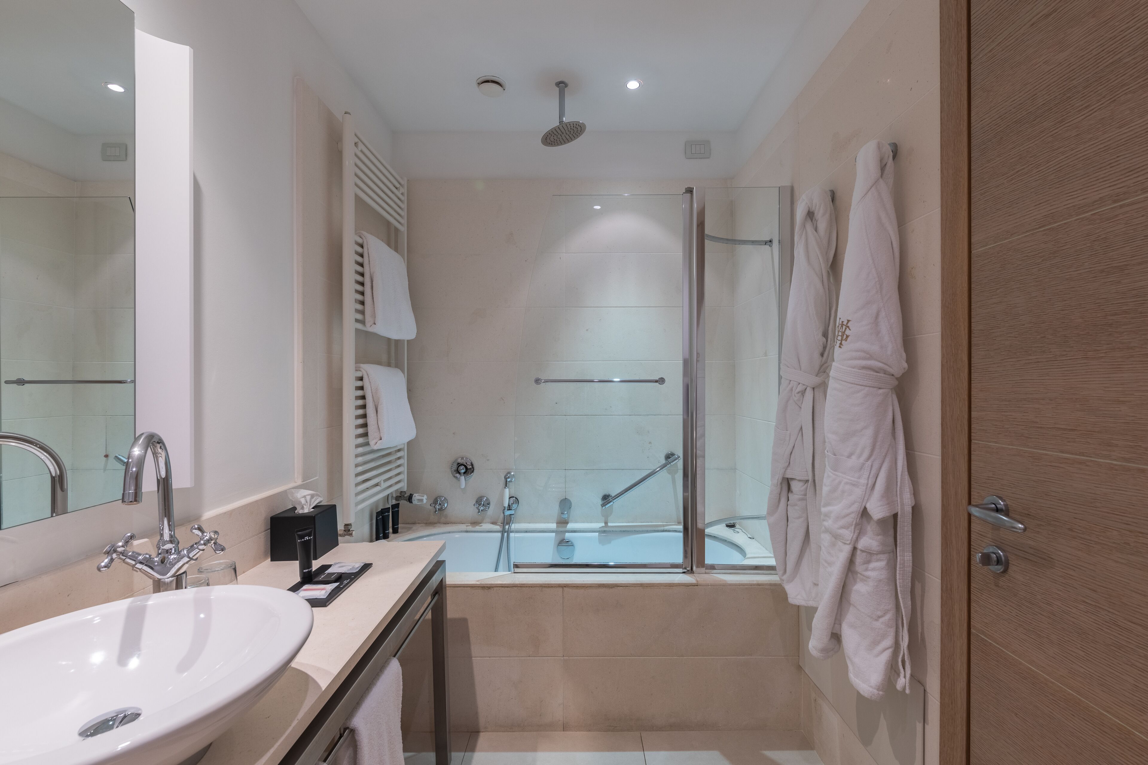 Ein modernes Badezimmer mit einem großen Waschbecken, einer Badewanne und einer Dusche.