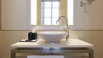 Un baño con un lavamanos grande de color blanco, un espejo y una ventana sobre el lavamanos.