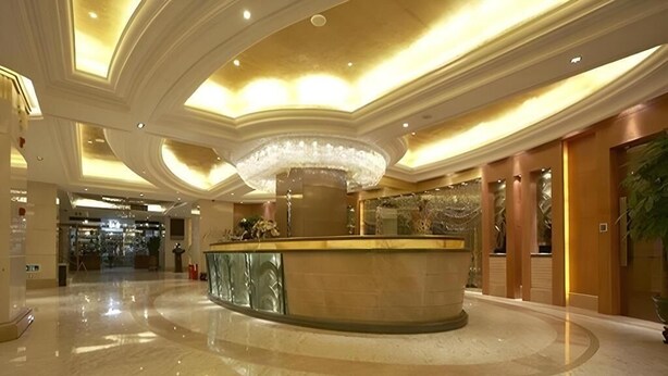 A spacious lobby with a marble floor, a central reception desk, and a large chandelier. - Ambassador Hotel Shenzhen (Shenzhen)